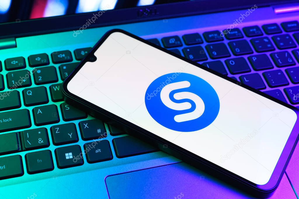 Prague, Czechia - 09 02 2025: Phone on laptop keyboard lit by colored light shows Shazam logo. Shazam is an app for identifying songs and music tracks.