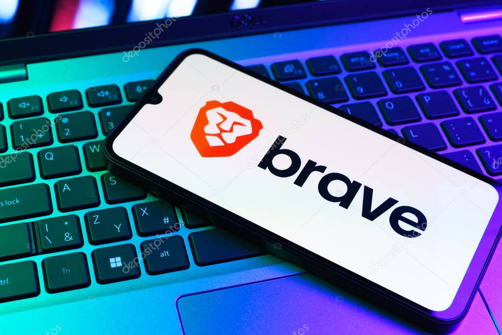 Prague, Czechia - 09 02 2025: Phone on laptop keyboard lit by colored light shows Brave logo. Brave is a web browser focused on privacy and speed.