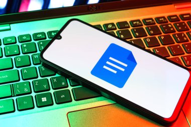 Prag, Çek Cumhuriyeti - 09 02 2025: Laptop klavyesindeki telefon renkli ışık göstergesi Google Docs logosunu gösteriyor. Google Docs metin belgeleri oluşturmak ve düzenlemek için bir platformdur.