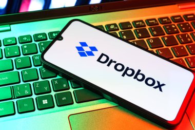 Prag, Çek Cumhuriyeti - 09 02 2025: Telefonun klavyesi renkli ışık gösteren Dropbox logosuyla aydınlatıldı. Dropbox bulut depolama ve dosya paylaşımı için bir platformdur.