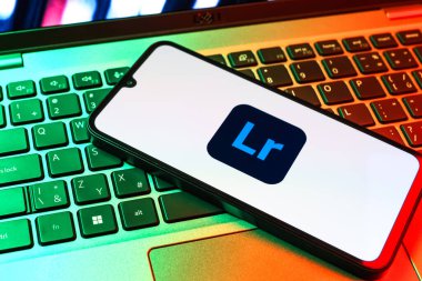 Prag, Çek Cumhuriyeti - 09 02 2025: Renkli ışık logosuyla aydınlatılan dizüstü bilgisayardaki telefon Lightroom logosunu gösteriyor. Lightroom fotoğraf düzenleme ve yönetim için bir yazılımdır..