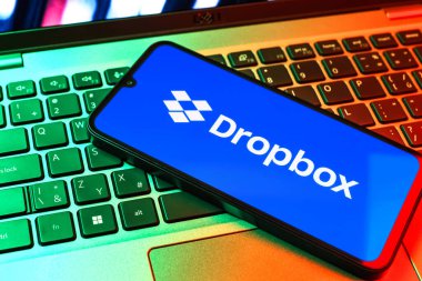 Prag, Çek Cumhuriyeti - 09 02 2025: Telefonun klavyesi renkli ışık gösteren Dropbox logosuyla aydınlatıldı. Dropbox bulut depolama ve dosya paylaşımı için bir platformdur.
