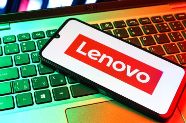 Prag, Çek Cumhuriyeti - 09 02 2025: Renkli ışıklarla aydınlatılmış dizüstü bilgisayardaki telefon Lenovo logosunu gösteriyor. Lenovo bilgisayar ve elektronik üreten bir teknoloji şirketidir..