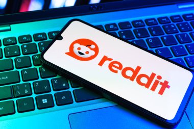 Prag, Çek Cumhuriyeti - 09 02 2025: Renkli ışık tarafından yakılan dizüstü bilgisayardaki telefon Reddit logosunu gösteriyor. Reddit tartışma, haber ve toplum içeriği için bir platformdur.