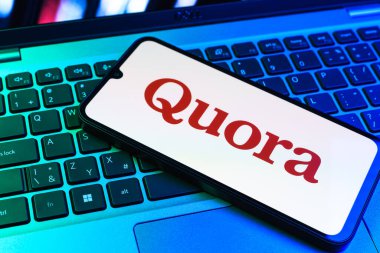 Prag, Çek Cumhuriyeti - 09 02 2025: Renkli ışık tarafından yakılan dizüstü bilgisayardaki telefon Quora logosunu gösteriyor. Quora soru sormak ve bilgi paylaşmak için bir platformdur..