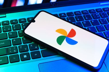 Prag, Çek Cumhuriyeti - 09 02 2025: Laptop klavyesindeki telefon renkli ışık göstergeleri Google Photos logosunu gösteriyor. Google Fotoğrafları fotoğraf ve videoları saklamak ve düzenlemek için bir platformdur.