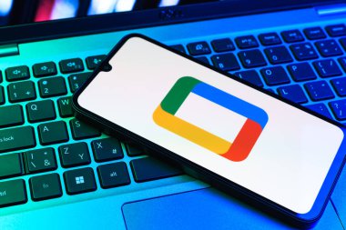 Prag, Çek Cumhuriyeti - 09 02 2025: Laptop klavyesindeki telefon renkli ışık gösterileri Google TV logosunu gösteriyor. Google TV film, program ve uygulamalar için bir platformdur..