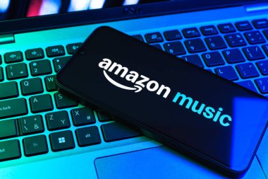 Prag, Çek Cumhuriyeti - 09 02 2025: Renkli ışık tarafından aydınlatılan dizüstü bilgisayardaki telefon Amazon Müzik logosunu gösteriyor. Amazon Müzik müzik müzik için bir platformdur..