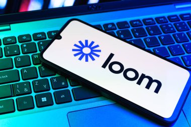 Prag, Çek Cumhuriyeti - 09 02 2025: Renkli ışık tarafından yakılan dizüstü bilgisayardaki telefon Loom logosunu gösteriyor. Loom video mesajlarını kaydetmek ve paylaşmak için bir platformdur.