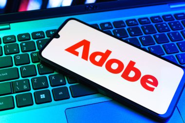 Prag, Çek Cumhuriyeti - 09 02 2025: Telefonun klavyesinde renkli ışık gösterileri Adobe logosu var. Adobe yaratıcı araçlar ve hizmetler sunan bir yazılım şirketidir..