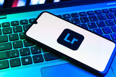Prag, Çek Cumhuriyeti - 09 02 2025: Renkli ışık logosuyla aydınlatılan dizüstü bilgisayardaki telefon Lightroom logosunu gösteriyor. Lightroom fotoğraf düzenleme ve yönetim için bir yazılımdır..