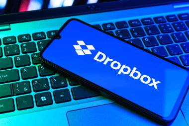 Prag, Çek Cumhuriyeti - 09 02 2025: Telefonun klavyesi renkli ışık gösteren Dropbox logosuyla aydınlatıldı. Dropbox bulut depolama ve dosya paylaşımı için bir platformdur.