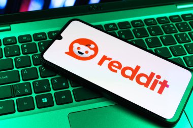 Prag, Çek Cumhuriyeti - 09 02 2025: Renkli ışık tarafından yakılan dizüstü bilgisayardaki telefon Reddit logosunu gösteriyor. Reddit tartışma, haber ve toplum içeriği için bir platformdur.