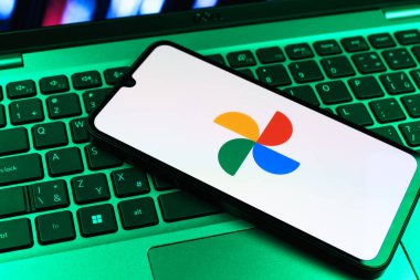 Prag, Çek Cumhuriyeti - 09 02 2025: Laptop klavyesindeki telefon renkli ışık göstergeleri Google Photos logosunu gösteriyor. Google Fotoğrafları fotoğraf ve videoları saklamak ve düzenlemek için bir platformdur.