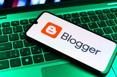 Prag, Çek Cumhuriyeti - 09 02 2025: Renkli ışık tarafından aydınlatılan dizüstü bilgisayardaki telefon blogger logosunu gösteriyor. Blogger blog oluşturma ve yayınlama için bir platformdur.