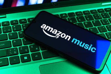 Prag, Çek Cumhuriyeti - 09 02 2025: Renkli ışık tarafından aydınlatılan dizüstü bilgisayardaki telefon Amazon Müzik logosunu gösteriyor. Amazon Müzik müzik müzik için bir platformdur..