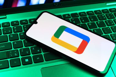 Prag, Çek Cumhuriyeti - 09 02 2025: Laptop klavyesindeki telefon renkli ışık gösterileri Google TV logosunu gösteriyor. Google TV film, program ve uygulamalar için bir platformdur..