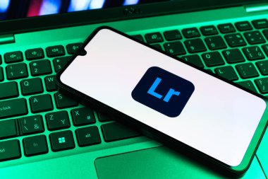 Prag, Çek Cumhuriyeti - 09 02 2025: Renkli ışık logosuyla aydınlatılan dizüstü bilgisayardaki telefon Lightroom logosunu gösteriyor. Lightroom fotoğraf düzenleme ve yönetim için bir yazılımdır..