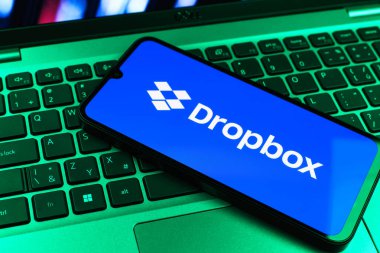 Prag, Çek Cumhuriyeti - 09 02 2025: Telefonun klavyesi renkli ışık gösteren Dropbox logosuyla aydınlatıldı. Dropbox bulut depolama ve dosya paylaşımı için bir platformdur.