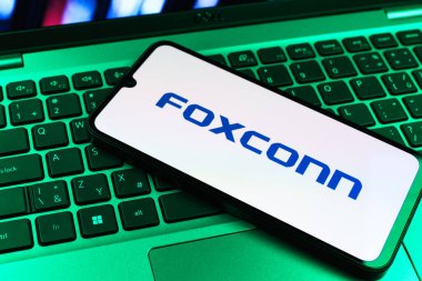 Prag, Çek Cumhuriyeti - 09 02 2025: Telefon dizüstü bilgisayarda renkli ışık tarafından aydınlatılmış Foxconn logosu. Foxconn elektronik ve parça üreten bir şirket..