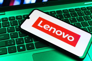 Prag, Çek Cumhuriyeti - 09 02 2025: Renkli ışıklarla aydınlatılmış dizüstü bilgisayardaki telefon Lenovo logosunu gösteriyor. Lenovo bilgisayar ve elektronik üreten bir teknoloji şirketidir..