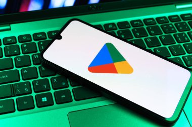 Prag, Çek Cumhuriyeti - 09 02 2025: Google Play logosunun renkli ışıklarla aydınlatıldığı dizüstü bilgisayardaki telefon. Google Play uygulamaları, oyunları ve dijital içeriği indirmek için bir platformdur.
