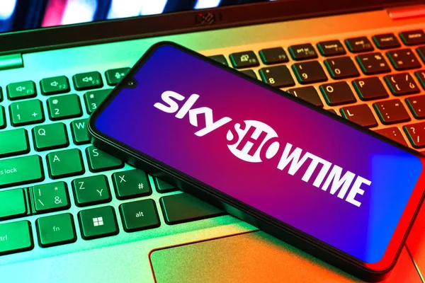 Prag, Çek Cumhuriyeti - 09 02 2025: Renkli ışık tarafından aydınlatılan dizüstü bilgisayardaki telefon SkyShowtime logosunu gösteriyor. SkyShowtime, sinema ve televizyon dizileri için bir yayın platformudur..