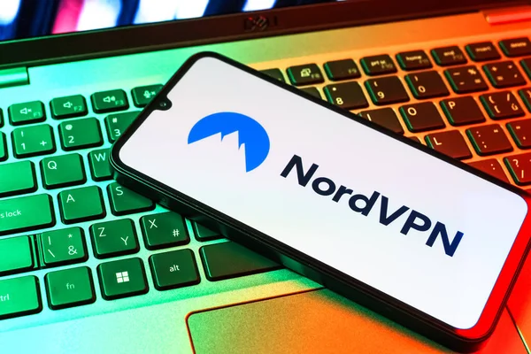 Prag, Çek Cumhuriyeti - 09 02 2025: Renkli ışık gösterileri NordVPN logosu tarafından yakılan dizüstü bilgisayardaki telefon. NordVPN güvenli ve özel internet taraması için bir platformdur.