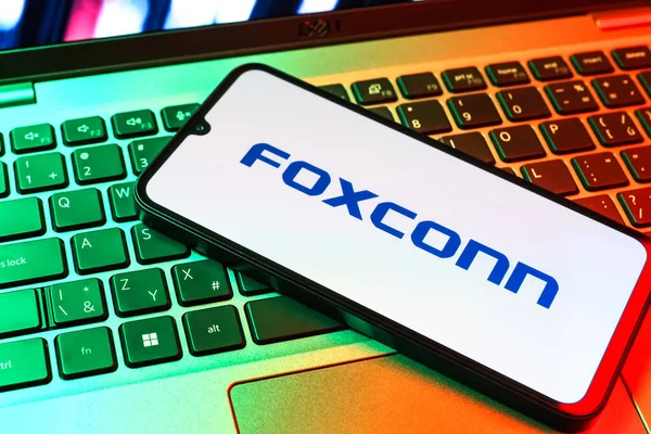 Prag, Çek Cumhuriyeti - 09 02 2025: Telefon dizüstü bilgisayarda renkli ışık tarafından aydınlatılmış Foxconn logosu. Foxconn elektronik ve parça üreten bir şirket..
