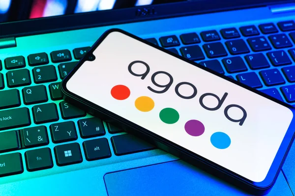 Prag, Çek Cumhuriyeti - 09 02 2025: Telefonun klavyesi renkli ışıklarla aydınlatılmış Agoda logosu gösteriyor. Agoda, otelleri ve seyahat yerlerini ayırtmak için bir platform..