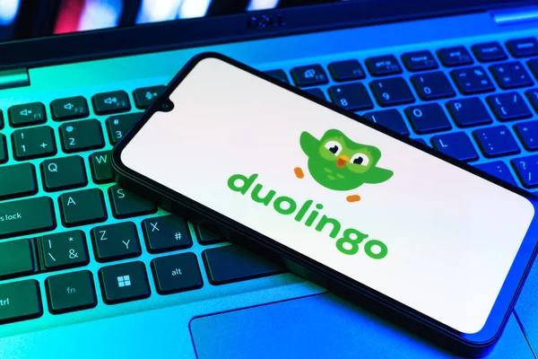 Prag, Çek Cumhuriyeti - 09 02 2025: Diz üstü bilgisayardaki telefon renkli ışık Duolingo logosunu gösteriyor. Duolingo interaktif olarak dil öğrenmek için bir platformdur..