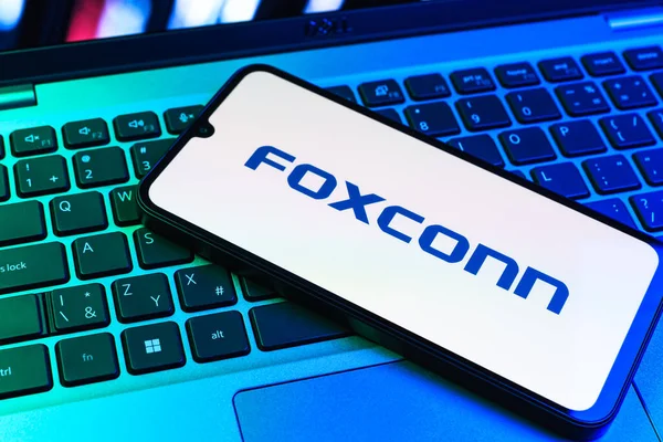 Prag, Çek Cumhuriyeti - 09 02 2025: Telefon dizüstü bilgisayarda renkli ışık tarafından aydınlatılmış Foxconn logosu. Foxconn elektronik ve parça üreten bir şirket..