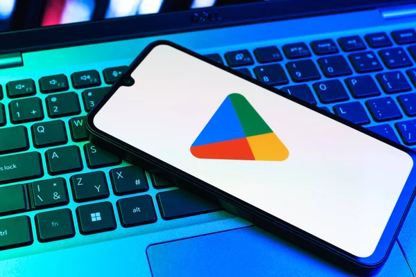 Prag, Çek Cumhuriyeti - 09 02 2025: Google Play logosunun renkli ışıklarla aydınlatıldığı dizüstü bilgisayardaki telefon. Google Play uygulamaları, oyunları ve dijital içeriği indirmek için bir platformdur.