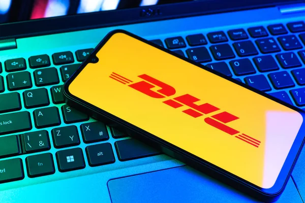 Prag, Çek Cumhuriyeti - 09 02 2025: DHL logosu renkli ışık tarafından yakılan dizüstü bilgisayardaki telefon. DHL uluslararası nakliye hizmeti sunan bir lojistik şirketidir..