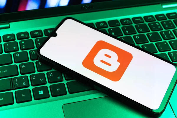 Prag, Çek Cumhuriyeti - 09 02 2025: Renkli ışık tarafından aydınlatılan dizüstü bilgisayardaki telefon blogger logosunu gösteriyor. Blogger blog oluşturma ve yayınlama için bir platformdur.