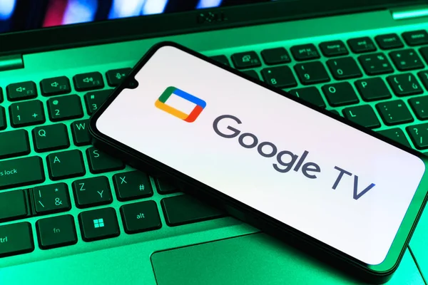 Prag, Çek Cumhuriyeti - 09 02 2025: Laptop klavyesindeki telefon renkli ışık gösterileri Google TV logosunu gösteriyor. Google TV film, program ve uygulamalar için bir platformdur..