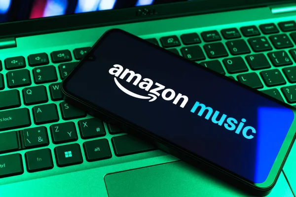 Prag, Çek Cumhuriyeti - 09 02 2025: Renkli ışık tarafından aydınlatılan dizüstü bilgisayardaki telefon Amazon Müzik logosunu gösteriyor. Amazon Müzik müzik müzik için bir platformdur..