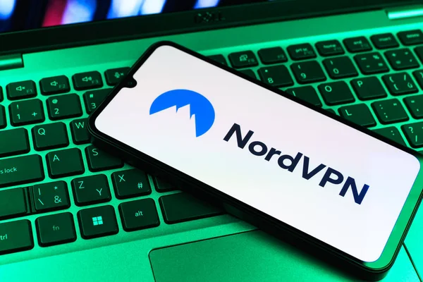 Prag, Çek Cumhuriyeti - 09 02 2025: Renkli ışık gösterileri NordVPN logosu tarafından yakılan dizüstü bilgisayardaki telefon. NordVPN güvenli ve özel internet taraması için bir platformdur.