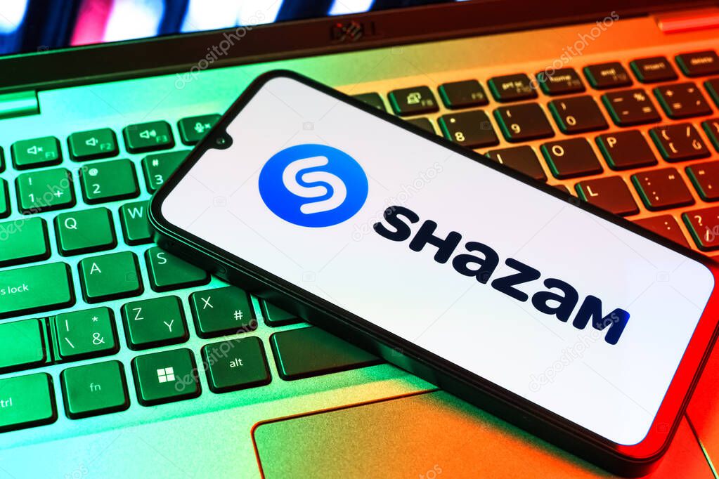 Prague, Czechia - 09 02 2025: Phone on laptop keyboard lit by colored light shows Shazam logo. Shazam is an app for identifying songs and music tracks.
