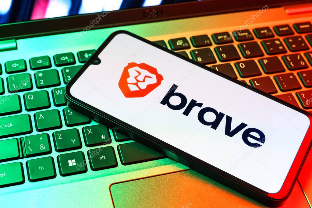 Prague, Czechia - 09 02 2025: Phone on laptop keyboard lit by colored light shows Brave logo. Brave is a web browser focused on privacy and speed.