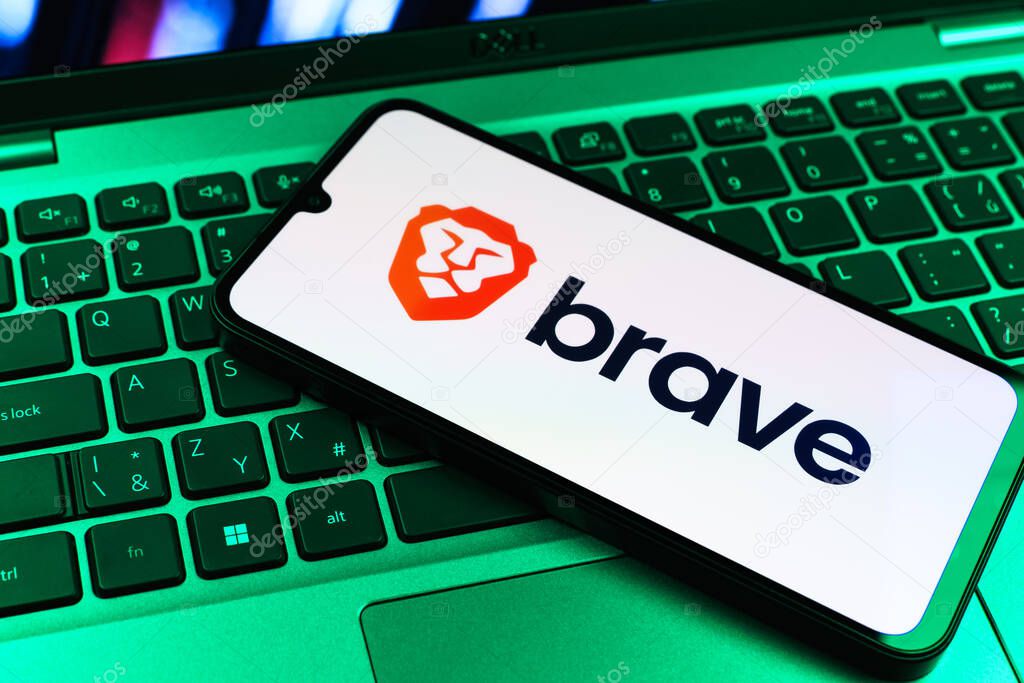 Prague, Czechia - 09 02 2025: Phone on laptop keyboard lit by colored light shows Brave logo. Brave is a web browser focused on privacy and speed.