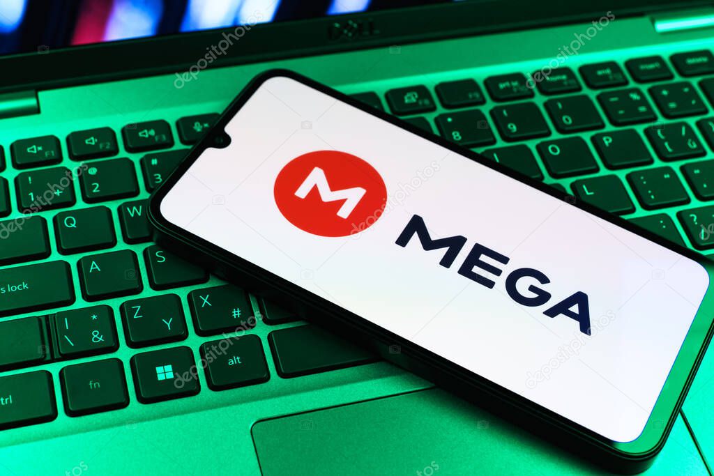 Prague, Czechia - 09 02 2025: Phone on laptop keyboard lit by colored light shows Mega logo. Mega is a platform for cloud storage with encrypted file sharing.