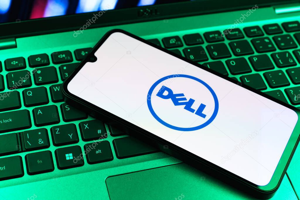 Prague, Czechia - 09 02 2025: Phone on laptop keyboard lit by colored light shows Dell logo. Dell is a technology company producing computers and IT solutions.
