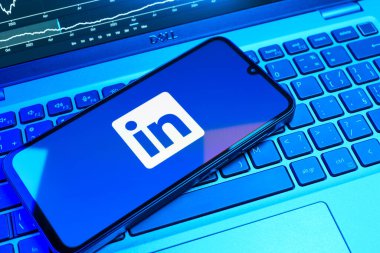 Prag, Çek Cumhuriyeti - 08 18 2025: Klavyede bir cep telefonu LinkedIn logosunu gösterir. LinkedIn, insanları ve şirketleri birbirine bağlayan profesyonel bir ağ..