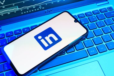 Prag, Çek Cumhuriyeti - 08 18 2025: Klavyede bir cep telefonu LinkedIn logosunu gösterir. LinkedIn, insanları ve şirketleri birbirine bağlayan profesyonel bir ağ..
