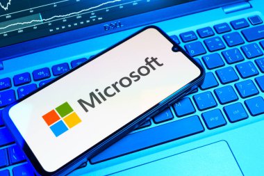 Prag, Çek Cumhuriyeti - 08 18 2025: Klavyede bir cep telefonu Microsoft logosu sergiler. Microsoft yazılım, donanım ve hizmet sunan bir teknoloji şirketidir..