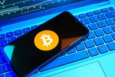Prag, Çek Cumhuriyeti - 08 18 2025: Klavyede bir cep telefonu Bitcoin logosu sergiler. Bitcoin merkezi olmayan işlemler için dijital bir kripto para birimidir.