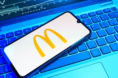 Prag, Çek Cumhuriyeti - 08 18 2025: Klavyede bir cep telefonu McDonalds logosu sergiler. McDonalds hamburger, patates kızartması ve daha fazlası sunan bir fast-food zinciri..