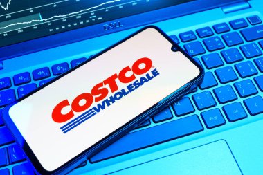 Prag, Çek Cumhuriyeti - 08 18 2025: Klavyede bir cep telefonu Costco logosu sergiler. Costco toptan satış yapan bir perakendecidir. Üyelere toptan ürün satar..