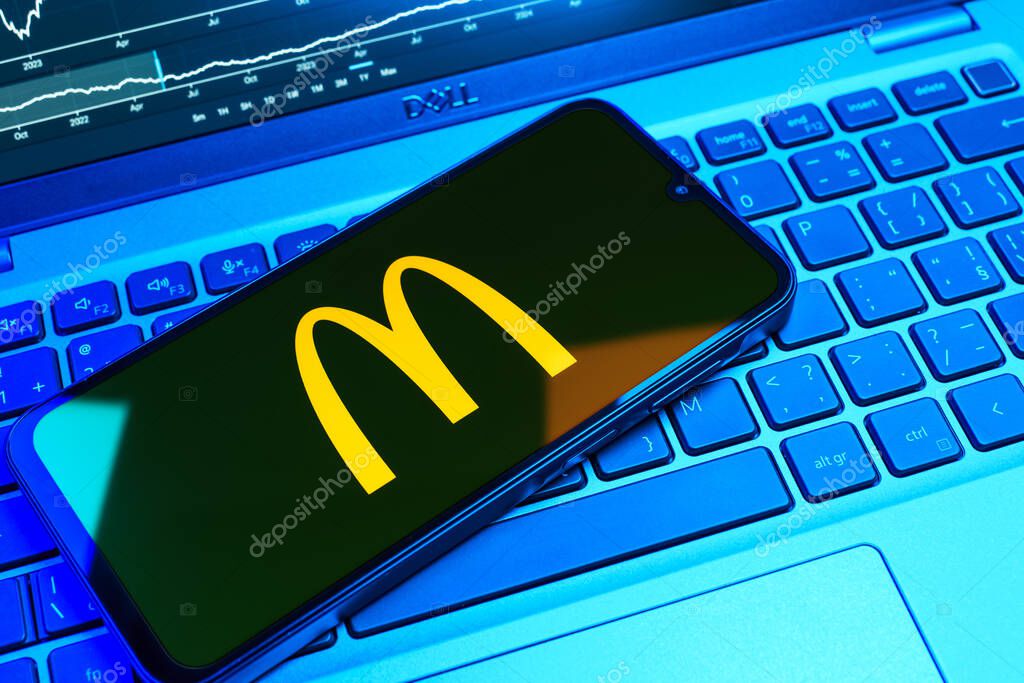 Prague, Czechia - 08 18 2025: A mobile phone on a keyboard displays McDonalds logo. McDonalds is a fast-food chain serving burgers, fries, and more.